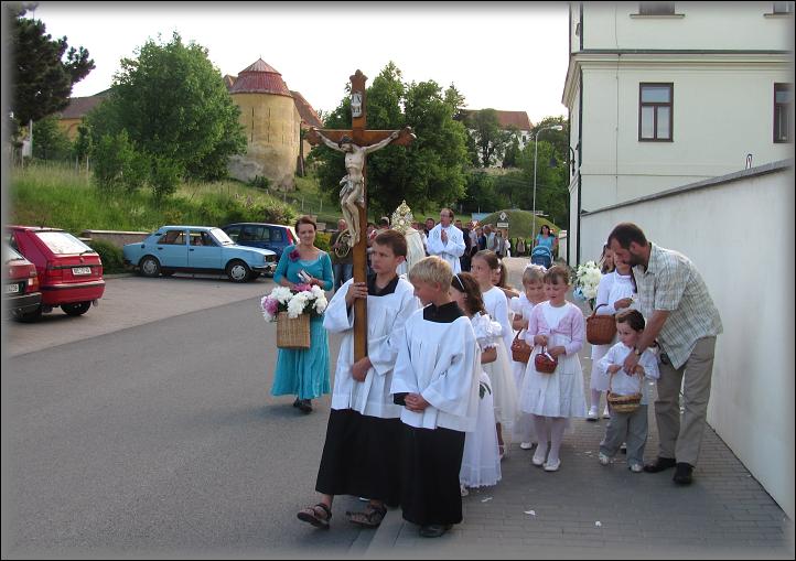  ministrant s křížkem opouští chodník