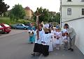  ministrant s křížkem opouští chodník
