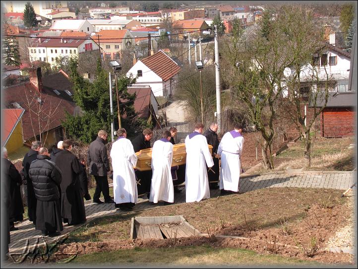  za rakví kráčejí řeholníci