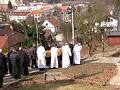  za rakví kráčejí řeholníci