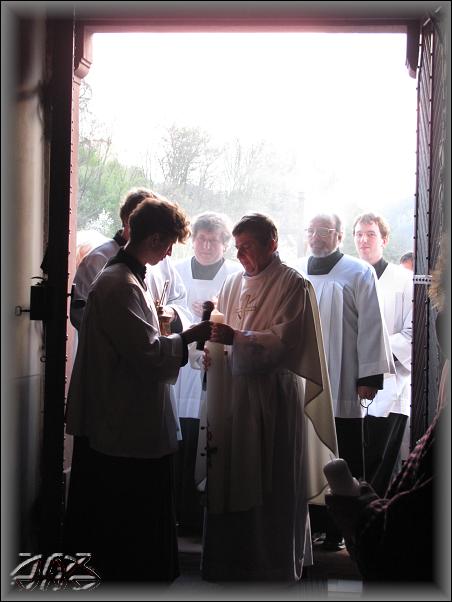 do setmělého kostela vchází kněz s rozžatým paškálem