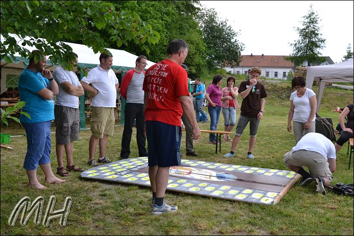 pan děkan připravuje bránu k transportu na hrací plochu, přihlíží duchovenstvo děkanátu