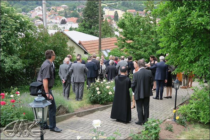 účastníci slavnosti živě diskutují venku na trávníku