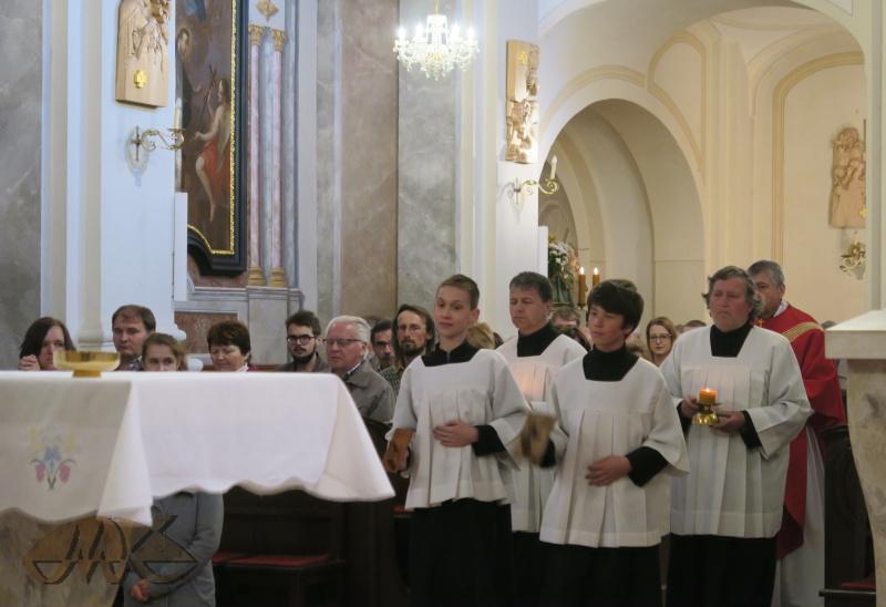 průvodem s klapačkami jsou přinášeny proměněné hostie