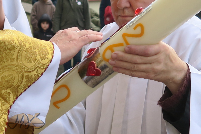 kněz rydlem obtahuje symboly na svíci